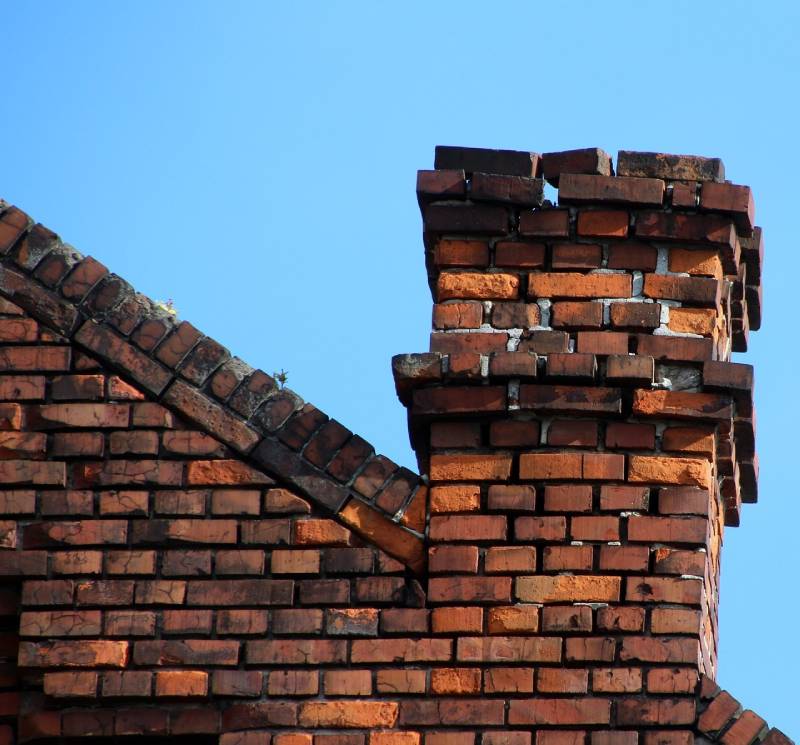 Damaged chimney on an Wilmington home showing cracks and missing mortar